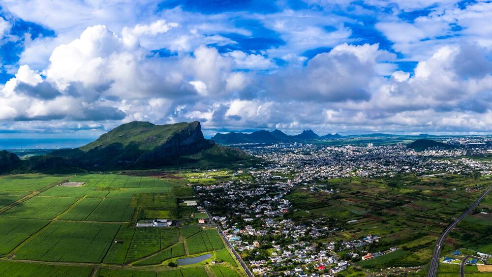 Mauritius, Black River, Flic-en-Flac, Helicopter view of island city with Corps de Garde mountain in background