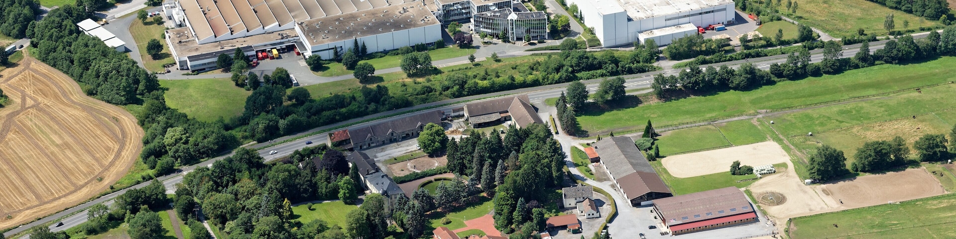 Luftaufnahme: Bundesstraße 7 in Hemer, Nordrhein-Westfalen; unten Edelburg mit Reitanlage, oben Gewerbegebiet u.a. mit Grohe-Werk und -Logistikzentrum