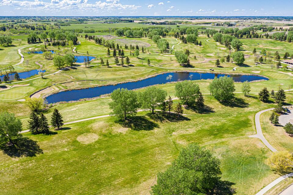 Un campo de golf con varios estanques y senderos sinuosos.