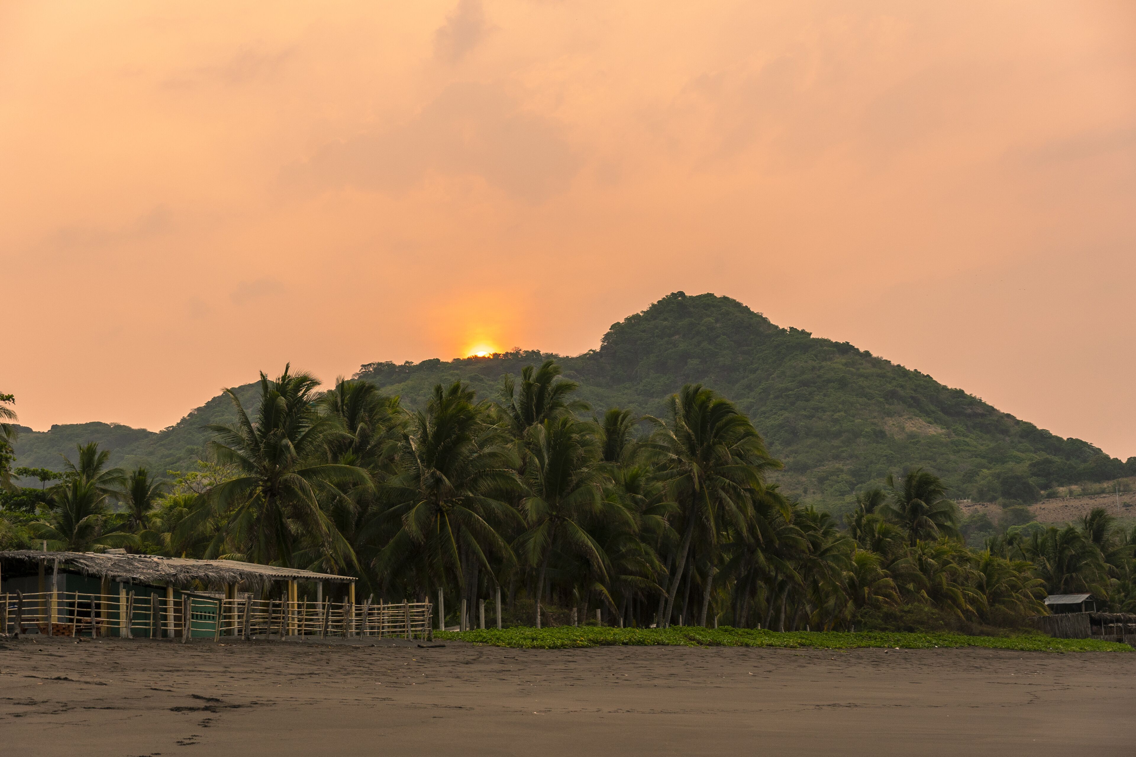 Sunset over lush greenery and beach at Mizata, El Salvador