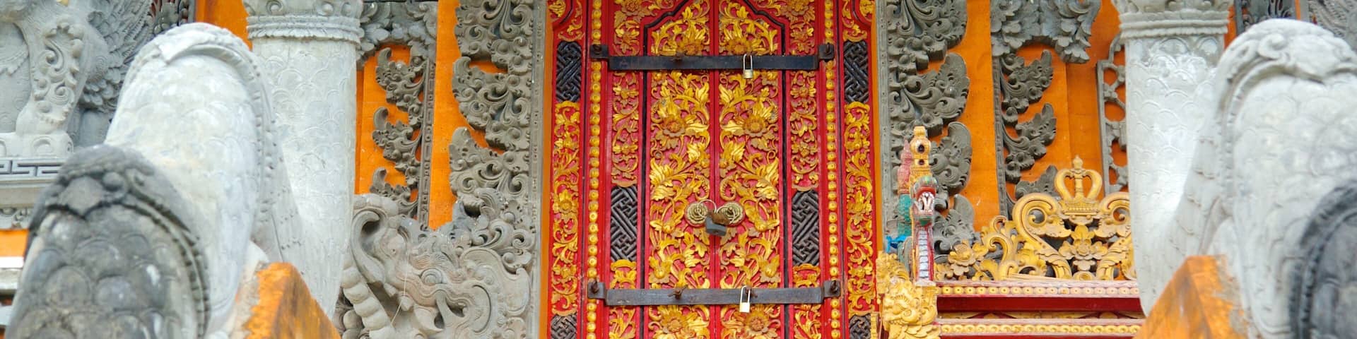 An ornate temple entrance with intricate carvings and a vibrant red and gold door.