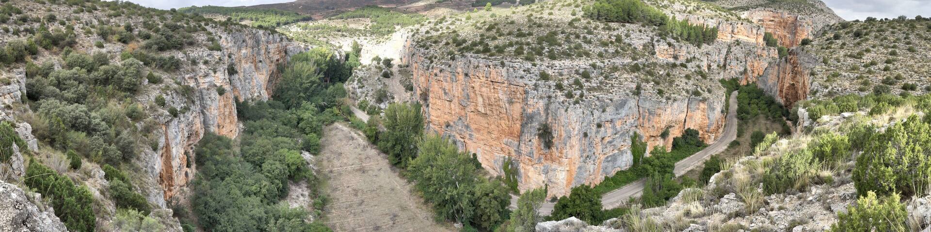The Barranco de la Hoz Seca (Dry Defile Gully) canyon, with scarps, bushes and red rocks, in a cloudy atumn, in the Jaraba rural town, Aragon, Spain