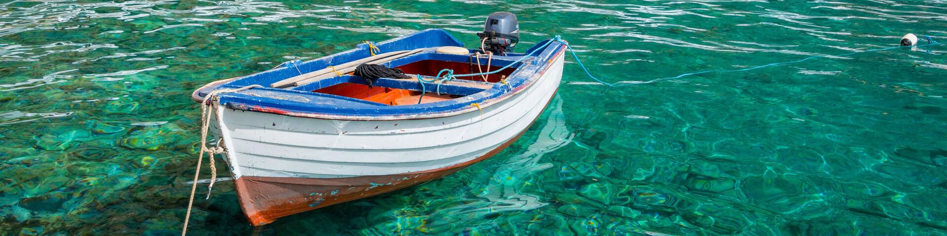 Fishing boat and the scenic greek village of Loutro in Crete, Greece