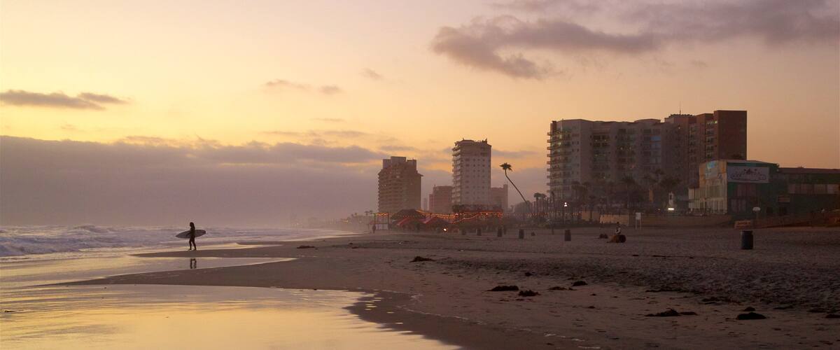 Rosarito which includes general coastal views, a sunset and a sandy beach