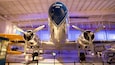 Un avion d’époque, portant le numéro 44V sur le devant de sa carlingue, est exposé dans un musée aux côtés d’autres avions historiques.