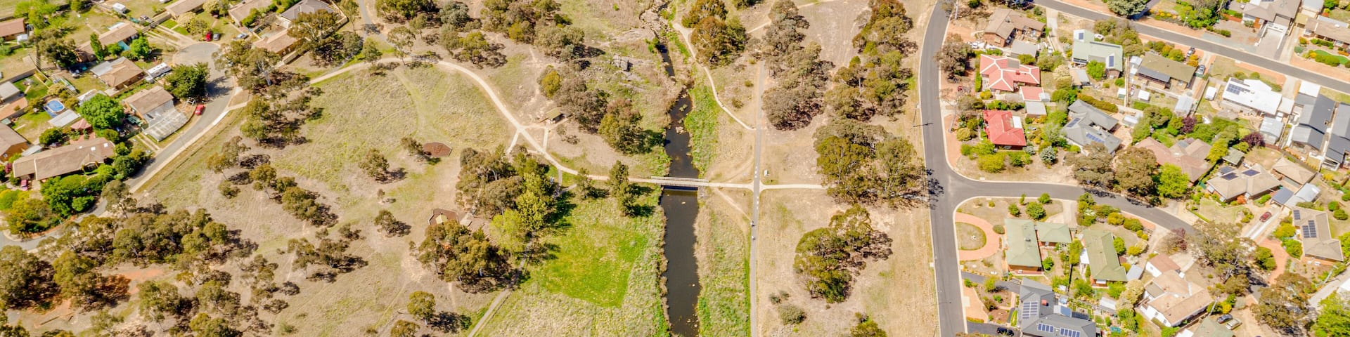 Aerial view of Umbagong District Park and Ginninderra Creek between the suburbs of Latham and Macgregor in Canberra, the Capital of Australia
