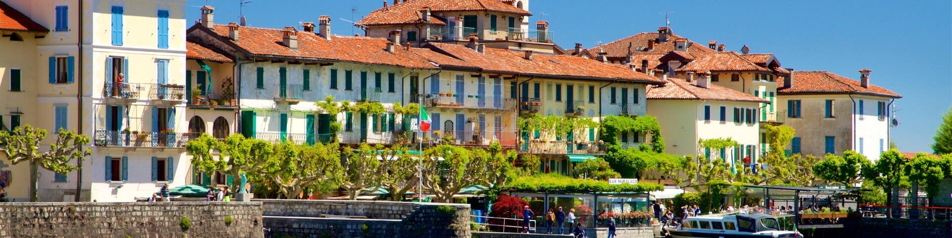 A waterfront town with historic buildings, a church spire, and boats on the water.