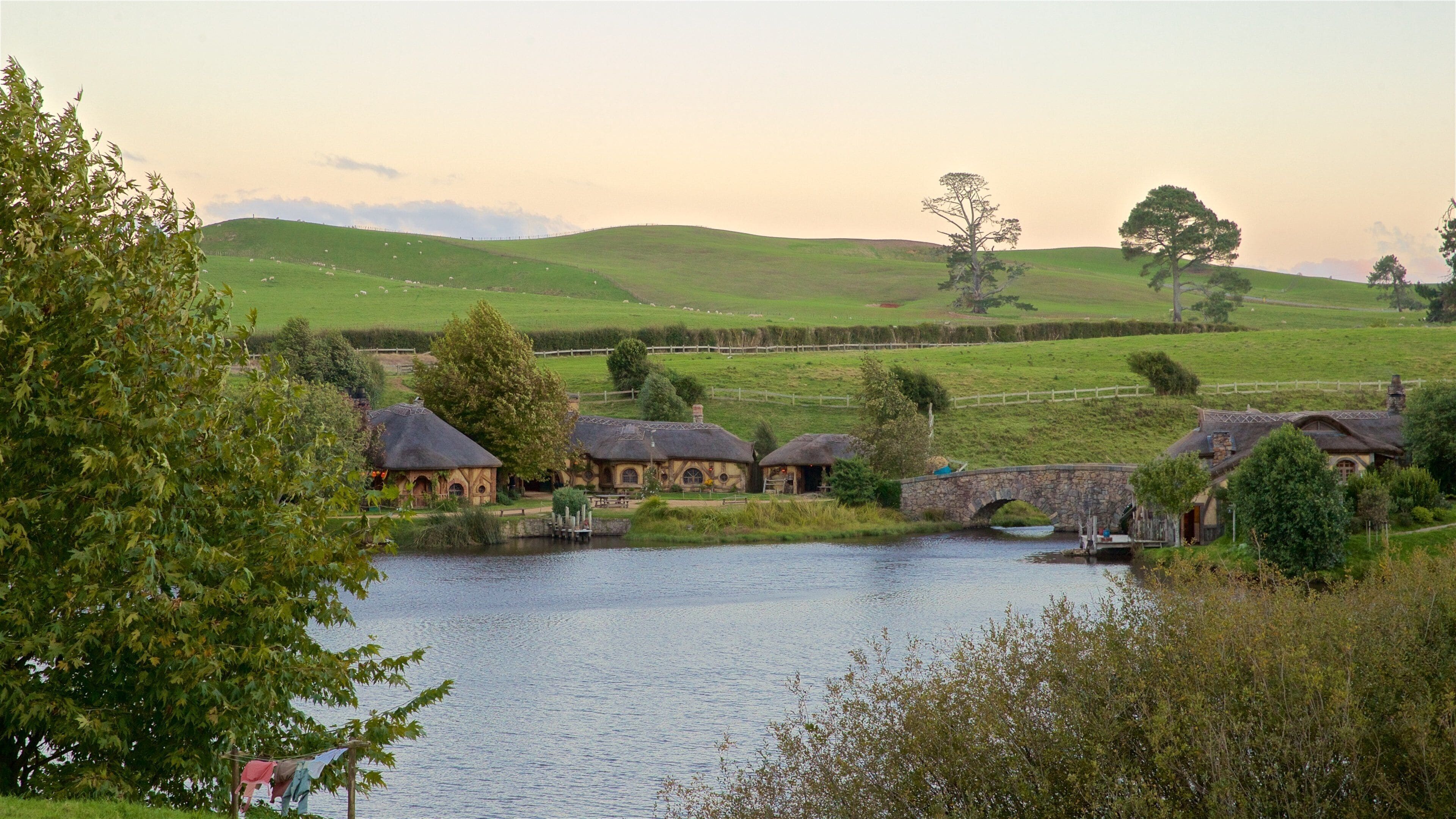 A river with houses and a stone bridge.