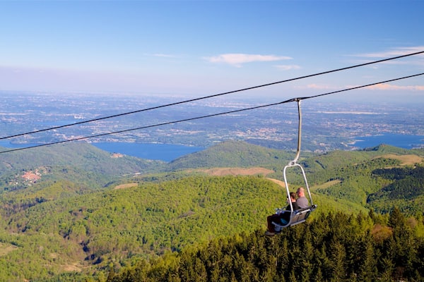 Eine Seilbahn über einer Berglandschaft mit einem See im Hintergrund.