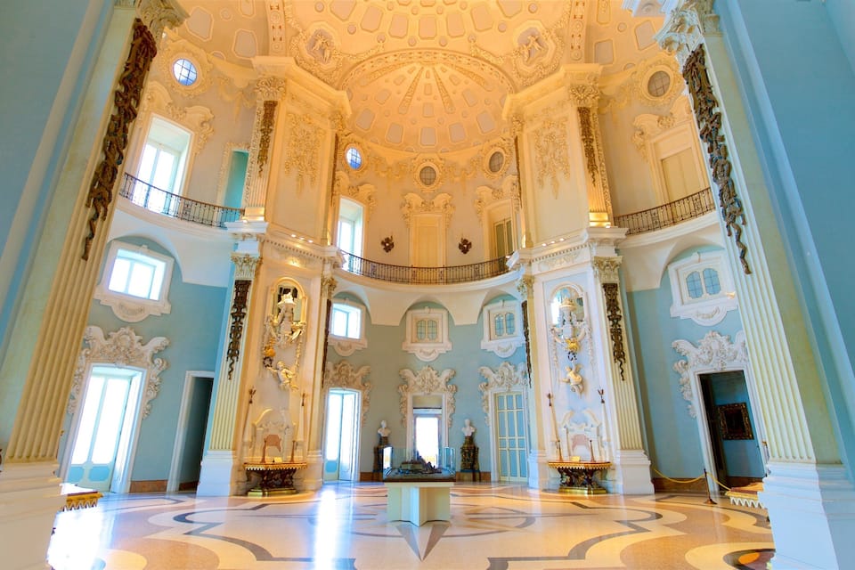Una maestosa sala con soffitti decorati, ampie finestre e colonne classiche.