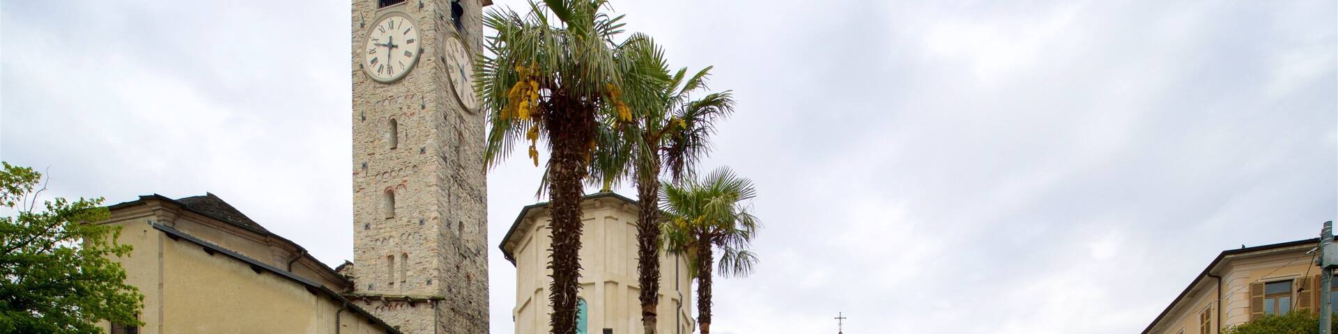A historic church with a tall bell tower, palm trees, and a stone staircase leading to the entrance.