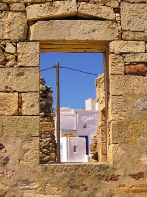 Chorio Village Kimolos: Chorio (or Chora) is the capital of Kimolos, located on the foot of Mount Xaplovouni. Chorio is found in the southeastern part of Kimolos. Kimolos has a sparse population and most of its inhabitants are concentrated there. In Chorio, you can see the typical Cycladic stone houses, narrow cobbled streets and a sense of an old charm prevailing all over. Many old buildings have been restored and new roads are being constructed to make it easier for tourists and residents. The best feature of Chorio is its traditional architecture: white washed houses with blue windows and flowered yards, which are built around the center of the old Venetian Castle. These houses portray true Aegean architectural style. The castle has two parts: Messa Kastro or the Inner Castle and Exo Kastro or the Outer Castle. They are also known as Palio Horio or Old Village and Neo Horio or New Village. In Messa Kastro, the outer walls of the houses have loopholes for windows, forming a defending wall.