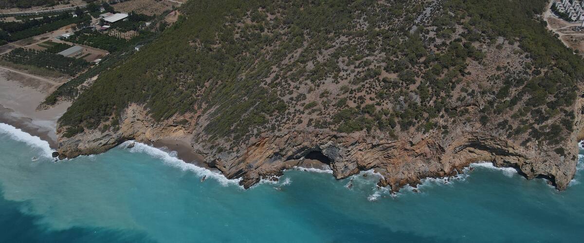 Aerial shot of a rocky hill in Yanisli Cave Beach, Gulnar, Mersin, Turkey