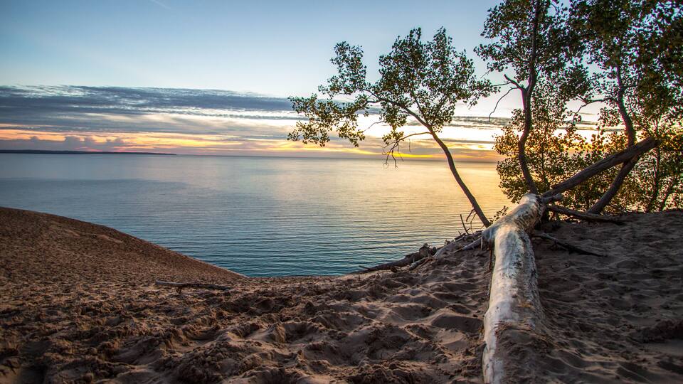 Sand Dune Overlook On Sunset Lake. Massive sand dune in Sleeping Bear Dunes National Lakeshore overlooking a sunset on Lake Michigan.