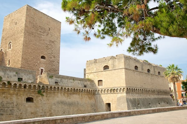A historic stone fortress with arched windows and a tall central tower.