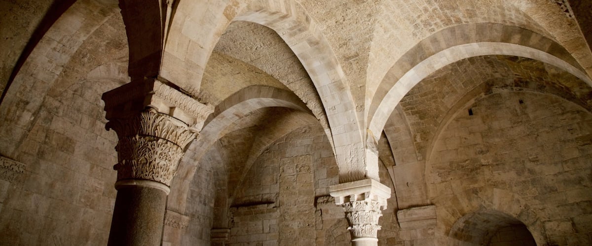 An interior with arched ceilings and stone columns.