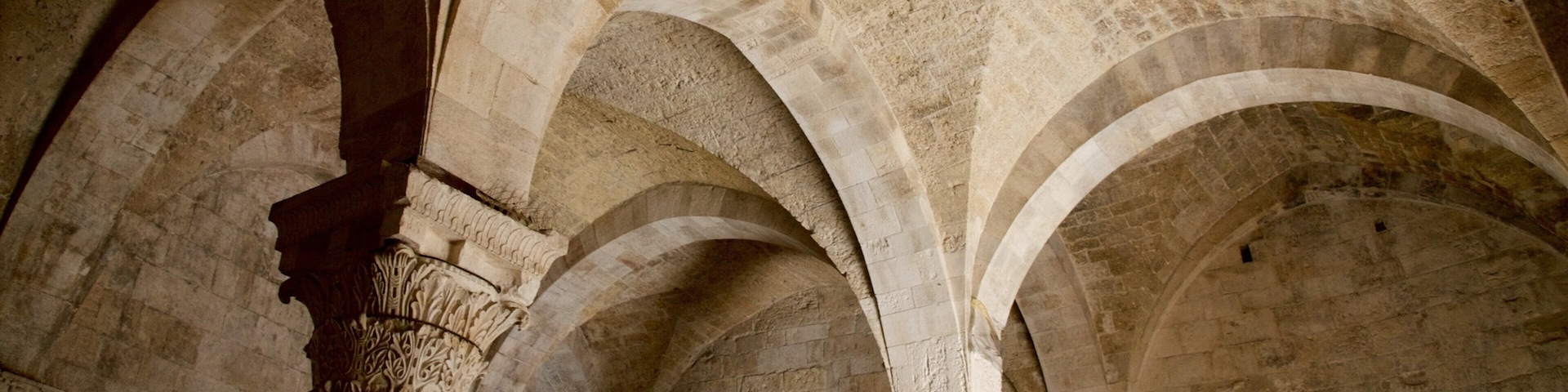 An interior with arched ceilings and stone columns.