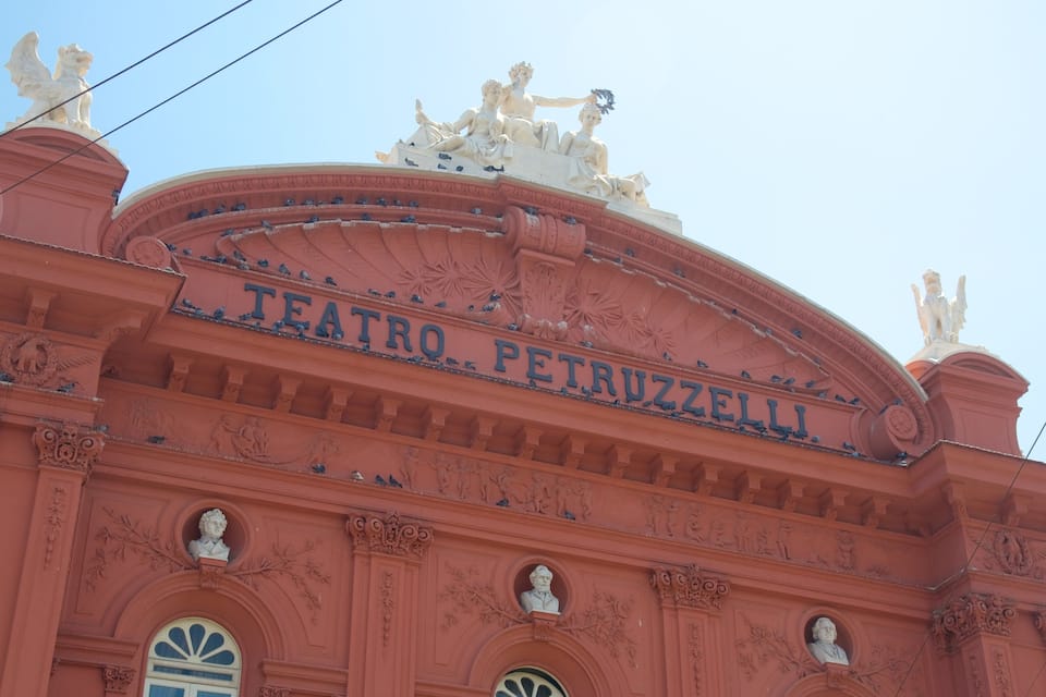 Teatro Petruzzelli with ornate sculptures and a red facade.