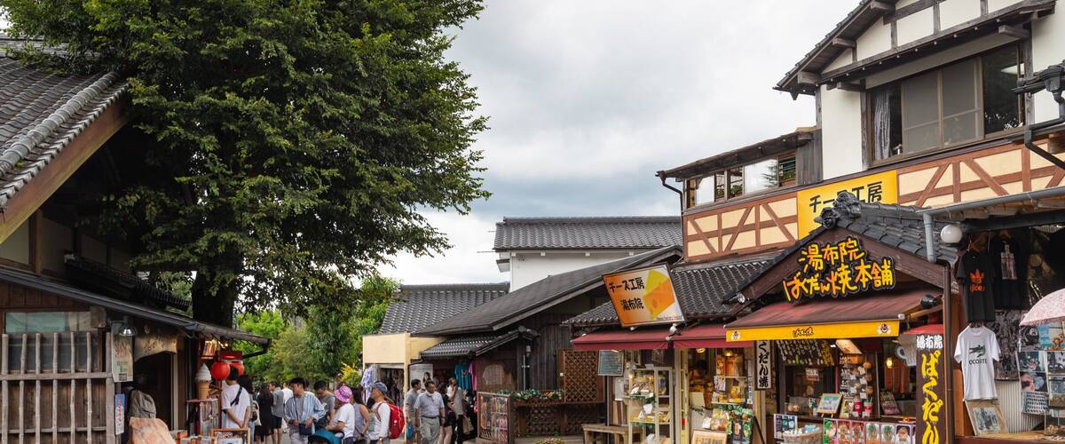 A traditional Japanese street with wooden buildings and a crowd of people.
