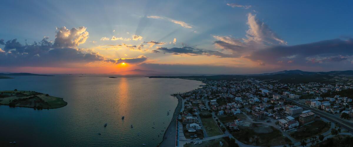 A sunset over a large body of water with a cityscape in the foreground.