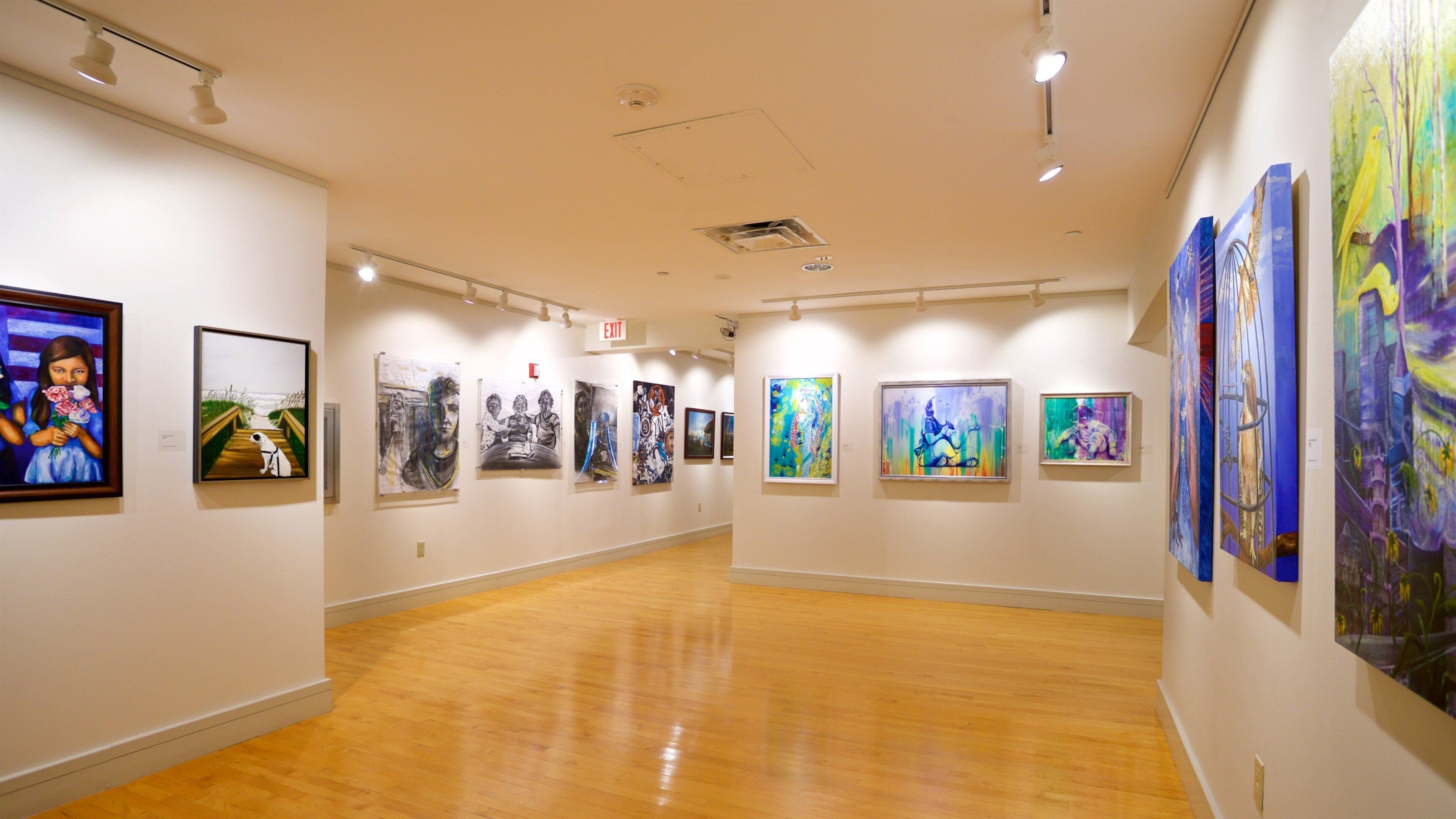 An art gallery with wooden floors and white walls.