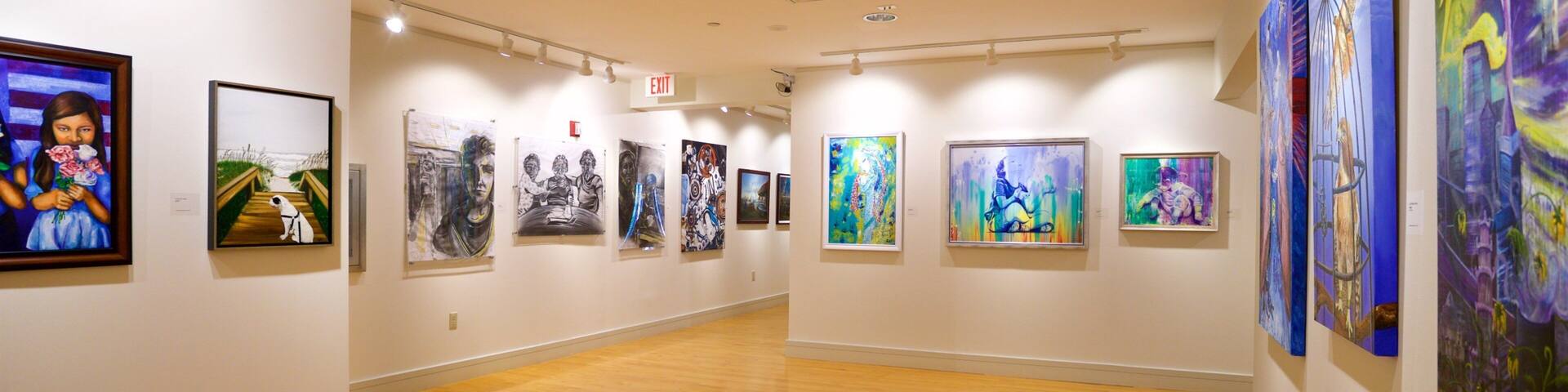 An art gallery with wooden floors and white walls.