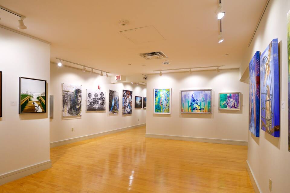 An art gallery with wooden floors and white walls.
