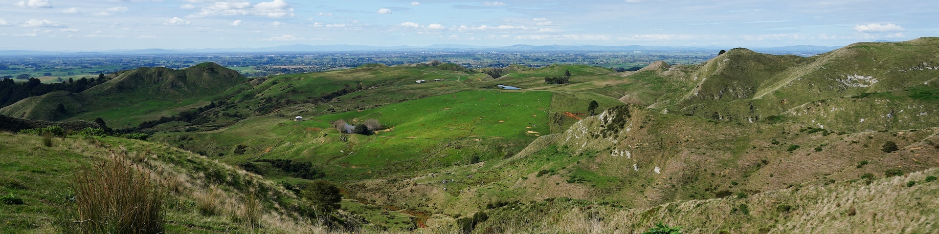 Colinas ondulantes, un lago distante y un cielo despejado.