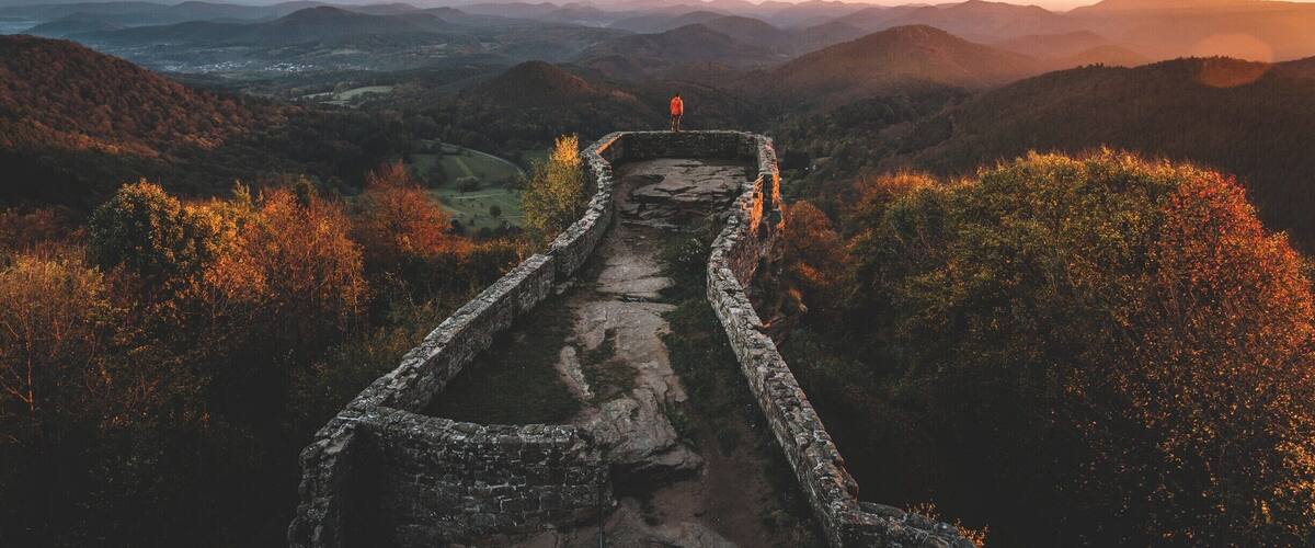 A stone pathway leading through a mountainous landscape with autumn foliage.