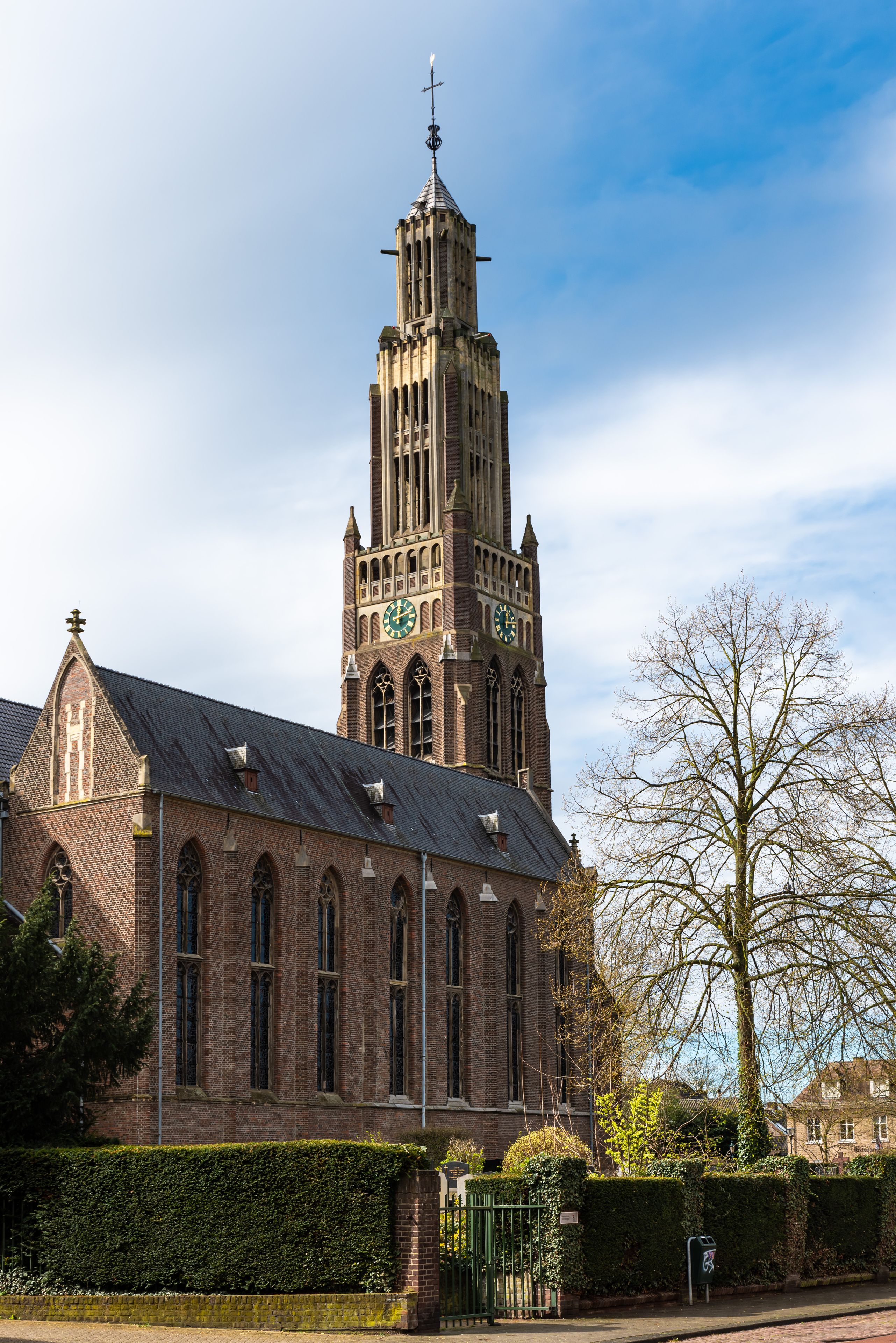 Une église historique dotée d’un haut clocher, de fenêtres en arc de cercle et d’une horloge.