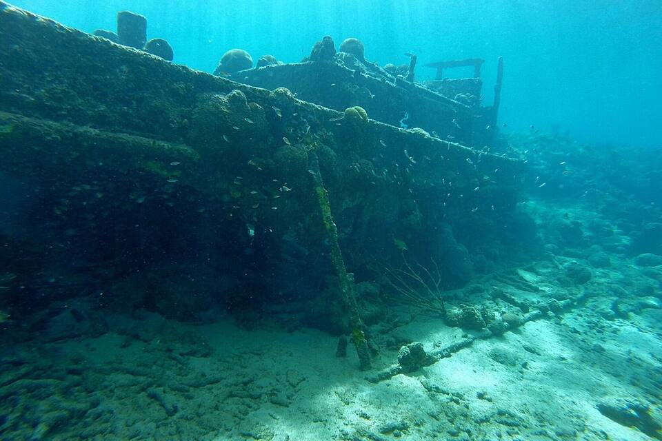 Un naufragio submarino con formaciones de coral y vida marina.