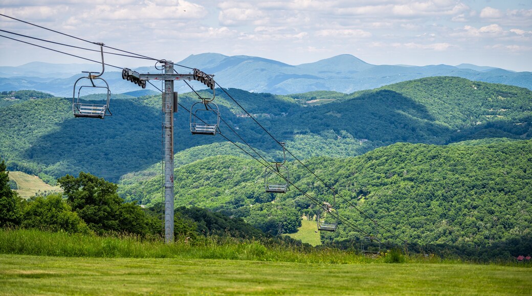 Sugar Mountain ski resort town park with view of ski chair lift slope and beautiful green lush foliage and clouds in North Carolina Blue Ridge Appalachia