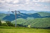 Sugar Mountain ski resort town park with view of ski chair lift slope and beautiful green lush foliage and clouds in North Carolina Blue Ridge Appalachia