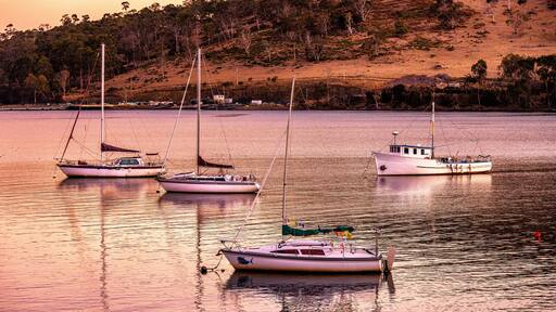 Boats at dusk at Port Huon, Tasmania, Australia