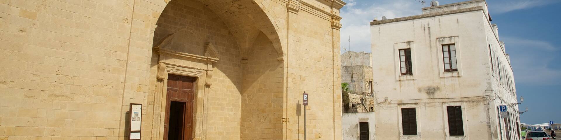 Un edificio histórico de piedra con una entrada arqueada y una torre del reloj.