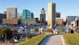 A marina with boats, a city skyline with modern buildings, and a clear blue sky.