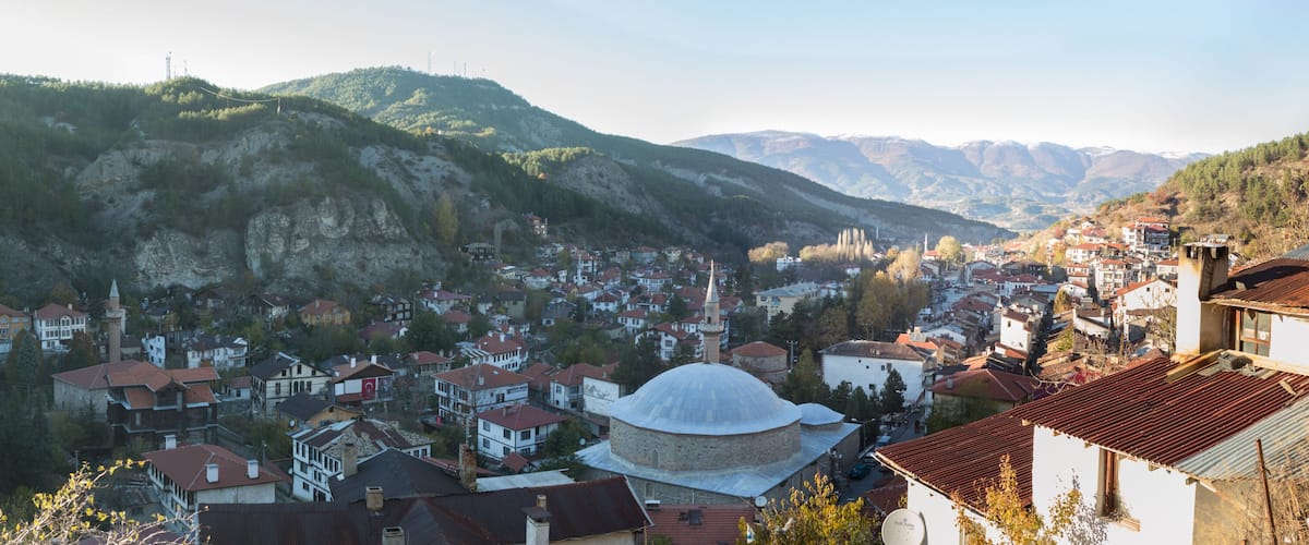 A mountainous town with a prominent mosque and a variety of residential buildings.