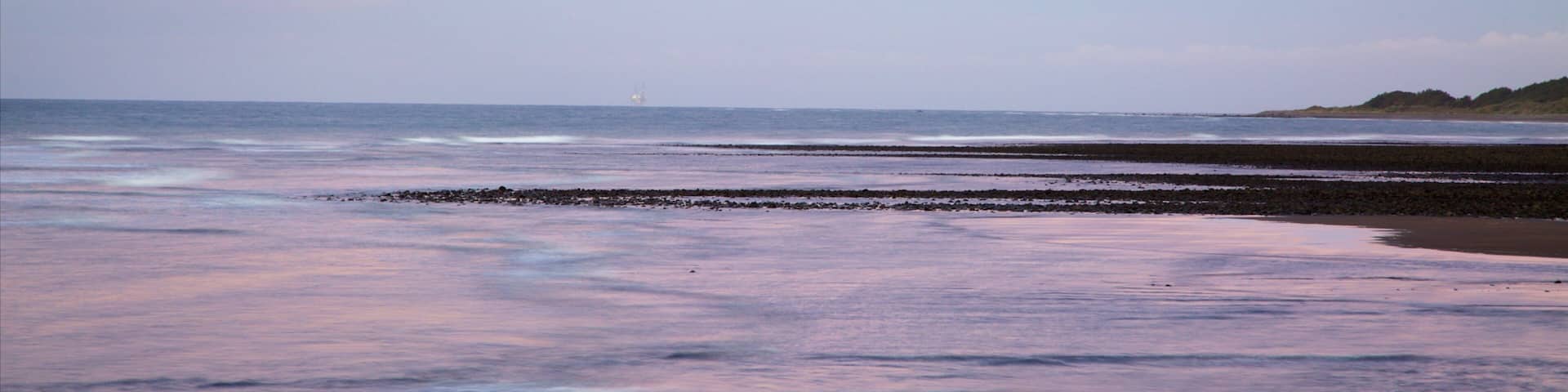 Fitzroy Beach featuring a sunset and a bay or harbor