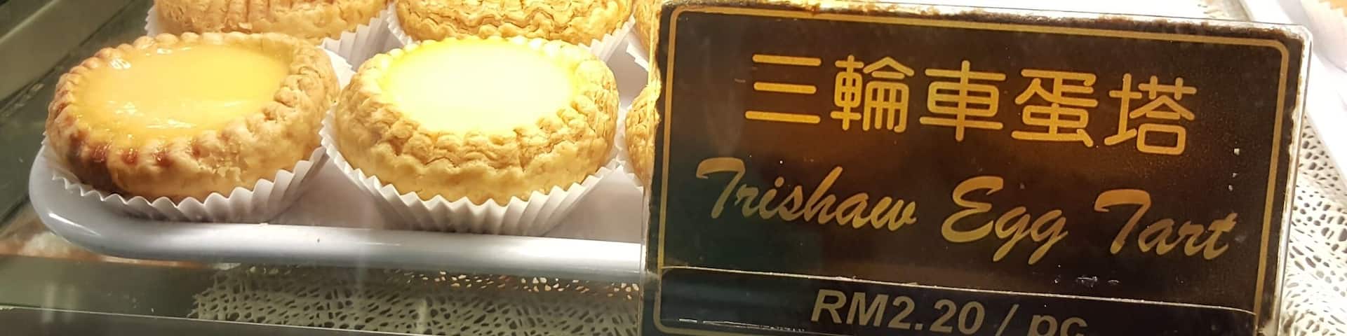A traditional Cantonese handmade pastry shop that dates back a few generations.
The business founder learnt the art of pastry making from his mother who was working in a dimsum teahouse, back in the heydays of tin-mining in Kampar.
To honour their parents' first pushcart business built from a converted trishaw, the 3rd generation named their egg tarts Trishaw Egg Tarts. They can be bought at this shop in Georgetown.