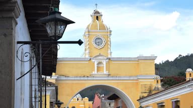 A yellow building with a clock tower and a dome.
