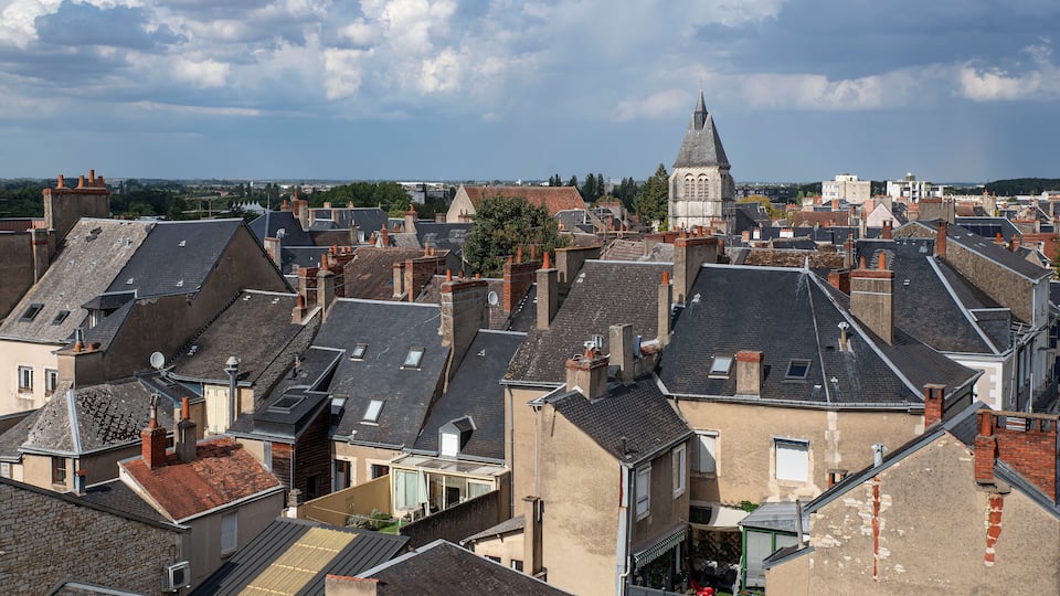 A densely packed urban area with a prominent church tower and a variety of rooftops.
