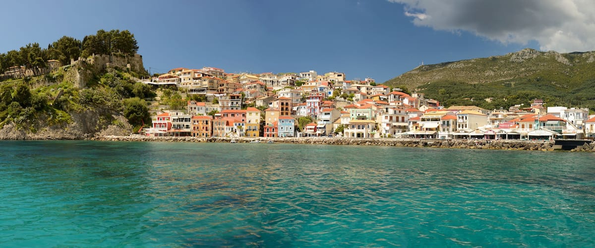 A coastal town with colorful buildings on a hillside overlooking turquoise waters.