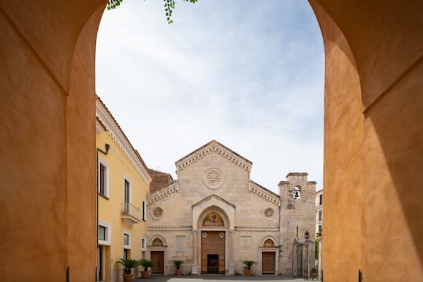 Un bâtiment historique doté d’un dôme central et d’une entrée en arc de cercle, encadrée par une arche en pierre.