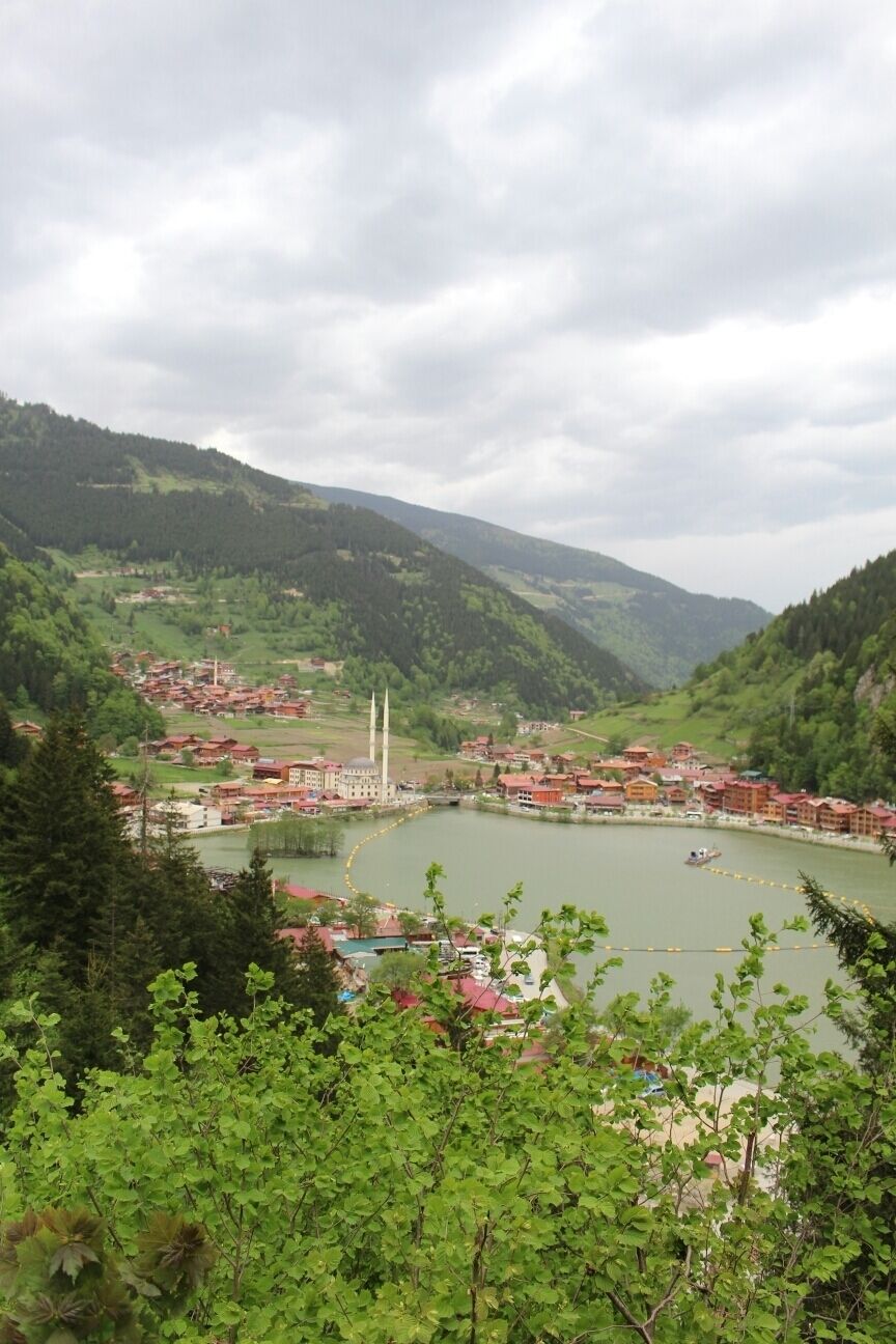 A town by a lake surrounded by mountains.