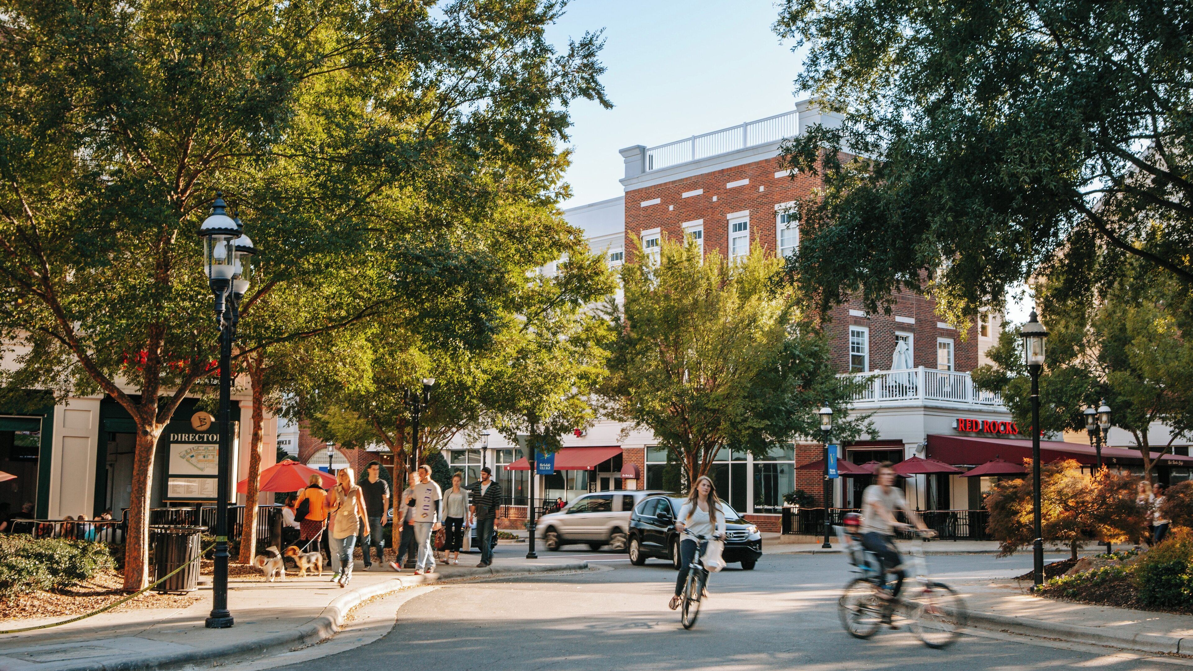 Vibrant community activity in Birkdale Village, Huntersville, North Carolina with pedestrians and cyclists enjoying the day