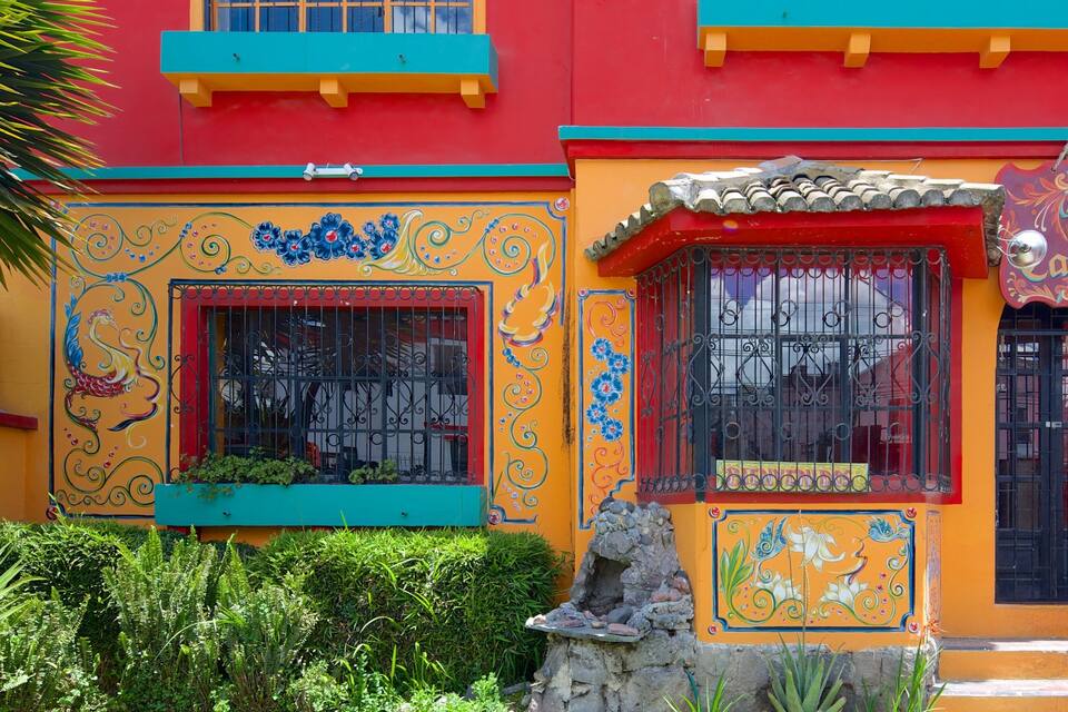 Un edificio colorido con murales vibrantes y un letrero que dice "La Carniceria".