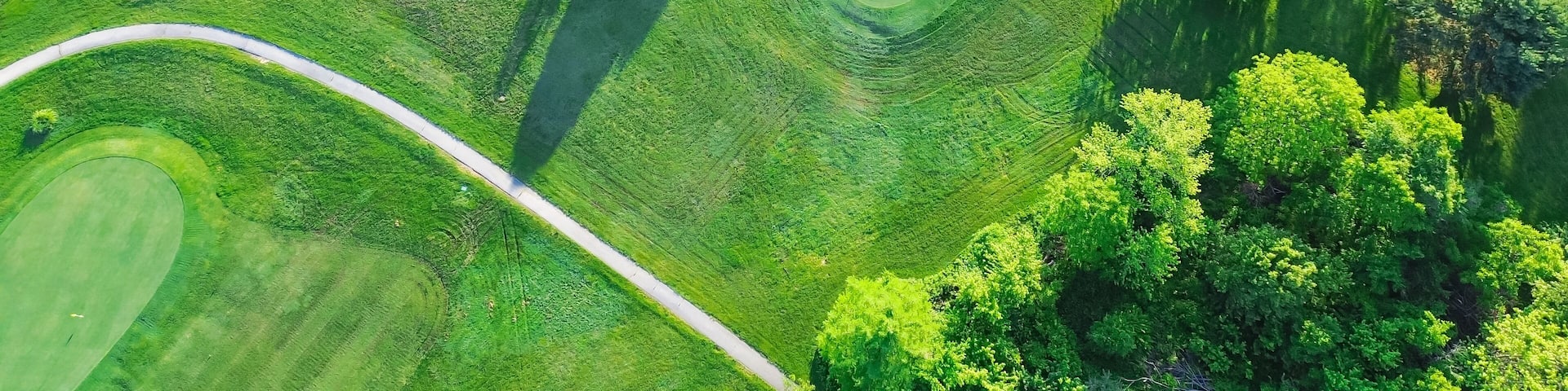 Straight aerial view cart path in 18 holes golf course, lavish greens sloping fairways, lots of trees at municipal country club in Mountain Grove, Missouri, scenic grassy lawn meadow laid back