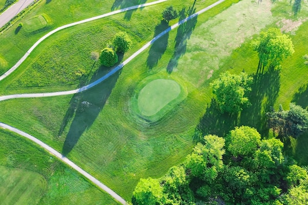 Straight aerial view cart path in 18 holes golf course, lavish greens sloping fairways, lots of trees at municipal country club in Mountain Grove, Missouri, scenic grassy lawn meadow laid back