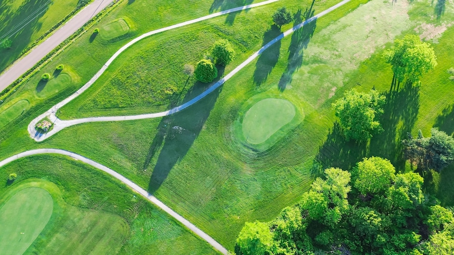 Straight aerial view cart path in 18 holes golf course, lavish greens sloping fairways, lots of trees at municipal country club in Mountain Grove, Missouri, scenic grassy lawn meadow laid back