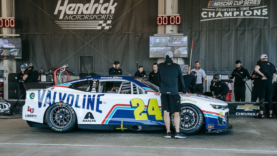 A race car with the number 24 parked at a pit stop.